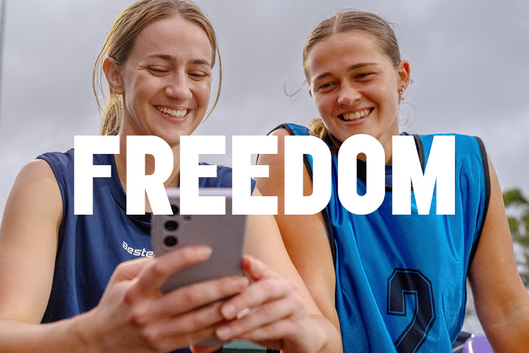 Two people sitting side by side looking at a mobile phone, with the word “Freedom” overlaid.