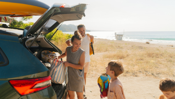 Happy family with car by the beach