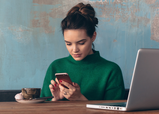 Woman working on phone in cafe.