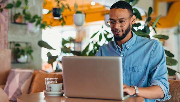 Man working on laptop at cafe.