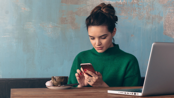 Woman working on phone in cafe.
