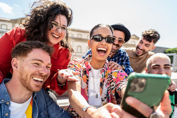 Friends taking a selfie outside in the sun.