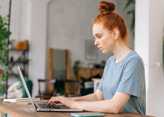 Woman at desk on laptop.