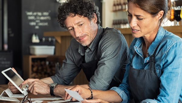 Man and woman recording receipts in cafe.
