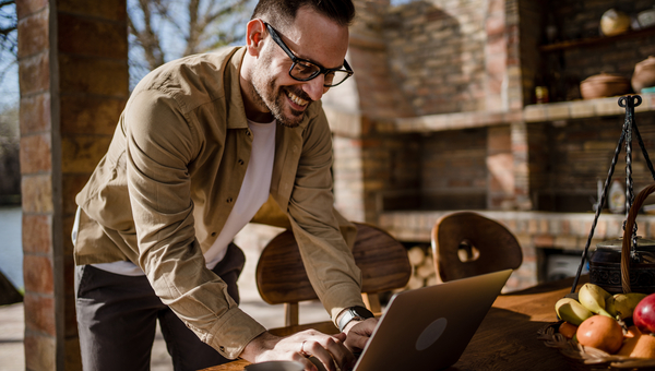Man smiling at laptop while working.