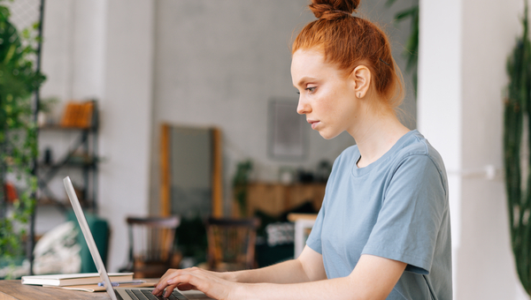 Woman at desk on laptop.
