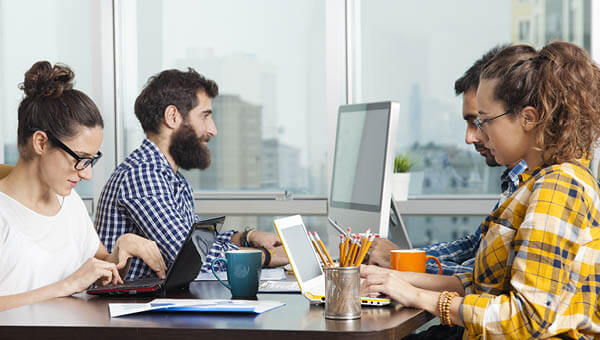 A team works closely together at their desks.