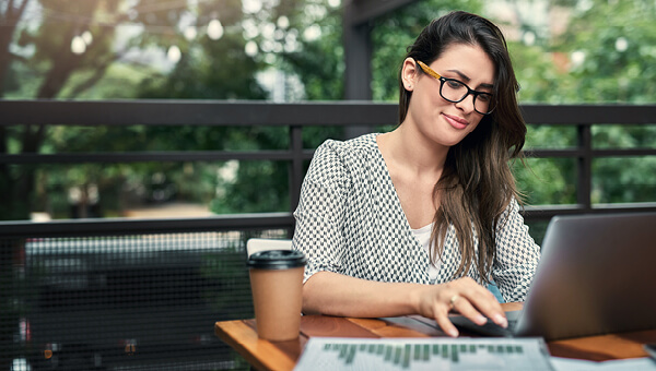 Woman using a laptop on her sunny patio. 