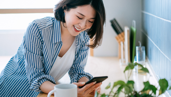 Woman checking phone while drinking coffee.