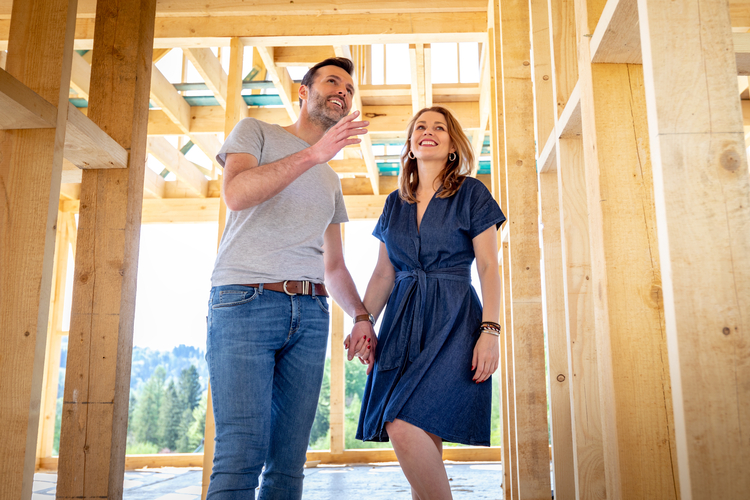 Couple inspecting new house frame.