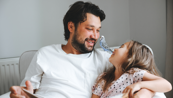 Father reads to daughter on the couch