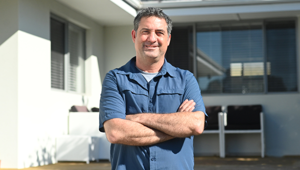 Man stands in front of his home
