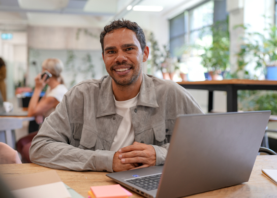 man smiling at work desk