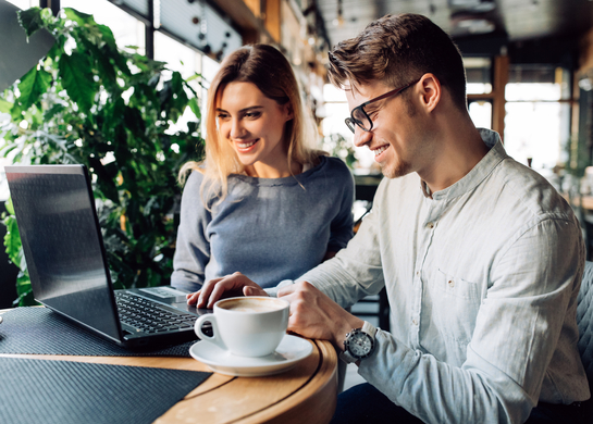 Two people look at laptop