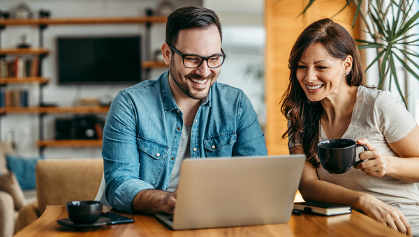 Couple looks at the laptop together