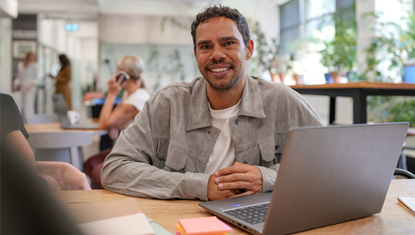 man smiling at work desk