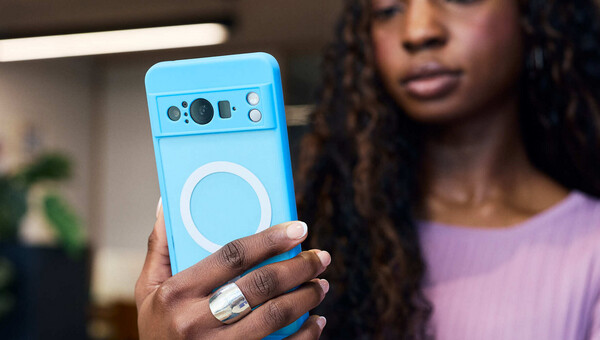 A person holding a blue mobile device and looking at the screen. 