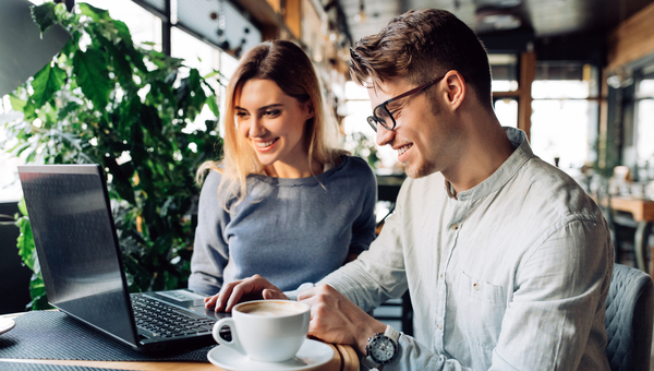 Two people look at laptop