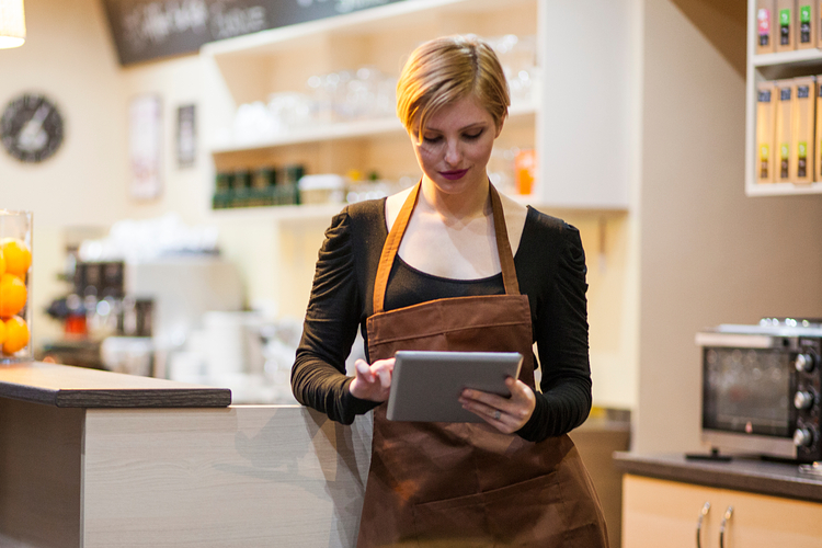 Cafe owner uses a tablet