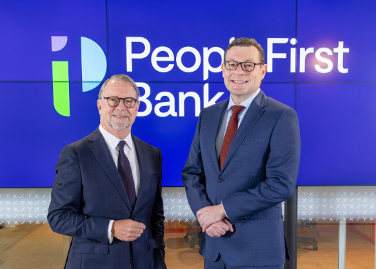 People First Bank Chairman Michael Cameron and CEO Steve Laidlaw standing side by side, smiling in front of the PFB logo. 