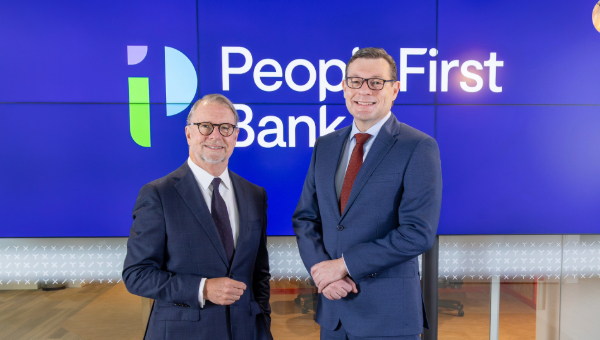 People First Bank Chairman Michael Cameron and CEO Steve Laidlaw standing side by side, smiling in front of the PFB logo. 