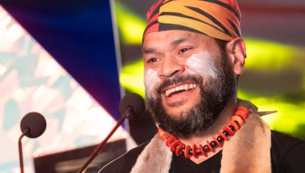 Petiola Wilson, a bearded man with white paint on his cheeks, conducts a Welcome to Country on Kaurna land, Adelaide.